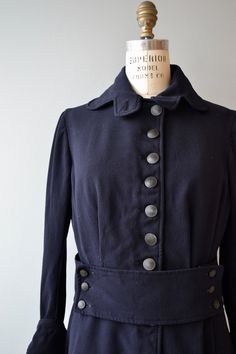 "Antique 1910s Edwardian jacket in deep navy blue gabardine wool with high buttoning scalloped collar, wide button front back repeated at the back, wide cuffed sleeves and double venting. Unlined (lining has been removed). --- M E A S U R E M E N T S --- fits like: medium shoulder: 16\" bust: 34-38\" waist: 34\" sleeve: 21\" length: 29\" brand/maker: n/a condition: excellent ★ layaway is available for this item ➸ More vintage coats http://www.etsy.com/shop/DearGolden?section_id=5800175 ➸ Visit t Tailored Navy Peacoat With Buttons, Formal Fitted Peacoat With Button Cuffs, Fitted Peacoat With Button Cuffs For Formal Occasions, Navy Pea Coat With Buttons For Work, Vintage Navy Single-breasted Outerwear, Navy Vintage Single Breasted Outerwear, Vintage Fitted Long Pea Coat, Navy Fitted Peacoat With Button Closure, Fitted Navy Peacoat With Button Closure