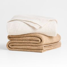 three folded blankets stacked on top of each other