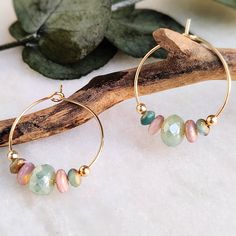 These unique and lightweight gorgeous 18k gold plated hoops are strung with Czech glass beads in rustic sea foam, dusky pink and sea blue/green. They have a mix of frosted/sea glass finish with a touch of gold, and opal luster green central bead. Easy to wear and would be great for summer and holiday wardrobes! All items come carefully packaged ready for gifting in sparkly tissue paper and a small jute bag with seaside charm. A white logo'd gift box is available for a small additional cost. Plea Gold Beaded Hoop Earrings For The Beach, Bohemian 14k Gold Filled Jewelry For Beach, Handmade 14k Gold Filled Jewelry For The Beach, Bohemian Dangle Hoop Earrings In 14k Gold Filled, Handmade 14k Gold Filled Beach Earrings, Handmade 14k Gold-filled Earrings For Beach, Handmade 14k Gold Filled Earrings For Beach, Bohemian 14k Gold Filled Dangle Hoop Earrings, Bohemian 14k Gold Filled Hoop Earrings