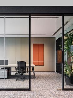 an office with glass walls and black chairs