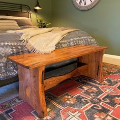 a wooden bench sitting in front of a bed on top of a carpeted floor