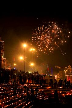 fireworks are lit up in the night sky over a city with lots of lights on it