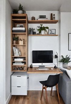 a living room with a couch, desk and shelves filled with books on top of it