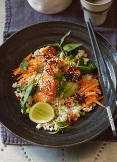 a black plate topped with rice and vegetables