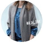 a woman wearing a gray knitted cardigan with the word kalbie written in white