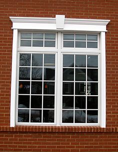 a red brick building with two windows and a clock on the side of it's face