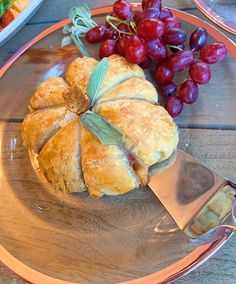 an orange plate topped with croissants and grapes