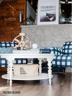 a white table sitting on top of a hard wood floor next to a blue checkered couch