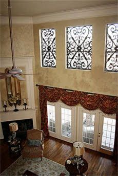 a living room with three windows and a fireplace