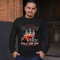 a man standing in front of a brick wall wearing an american trucker long sleeve t - shirt