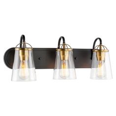 three light bathroom fixture with clear glass shades and gold accents on an aged bronze finish