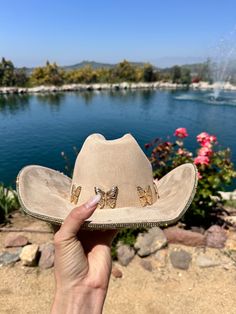 "Beige hat with yellow gold rhinestones on the bottom brim.  Beautiful butterflies line the trim.  This is one size fits most, there's a drawstring to adjust sizing.  ships in 2 business days! Stunning in person  Perfect for Coachella , stagecoach, Nashville, country concerts, bachelorette parties, brides, weddings Please note that the hats are handmade and may have some variances and blemishes. If any, they are very minor . The hats might have a bit of \"stickiness\" from the glue setting the rhinestones, this will improve over time." Gold Fedora Western Hat, Gold Western Fedora Hat, Gold Hat Bands For Rodeo Summer Events, Gold Hat Bands For Rodeo Summer, Gold Hat Bands For Rodeo In Summer, Gold Hat Bands For Summer Rodeo, Gold Hat Bands For Rodeo, Gold Flat Brim Hat For Rodeo, Gold Brimmed Hat For Rodeo