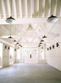 an empty room with several lights hanging from the ceiling