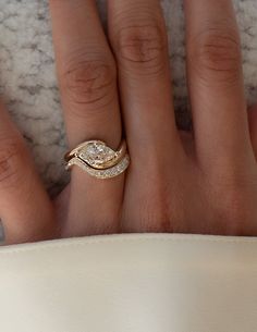 a woman's hand with two rings on top of her finger and the other ring in front of her