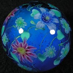 a blue glass ball with flowers painted on it