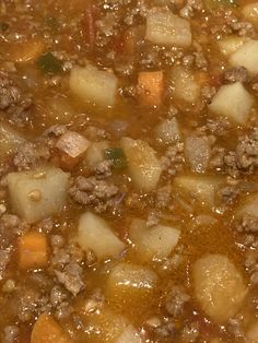 meat and vegetables are being cooked in a pot