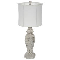 a white table lamp with a white shade on it's base and a light bulb in the middle