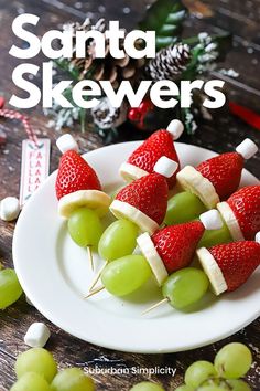 grapes and strawberries are arranged on skewers with marshmallows to make them look like santa