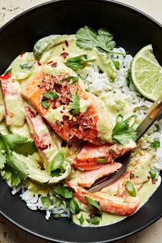 a black bowl filled with rice, shrimp and guacamole on top of it