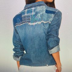 the back of a woman's jean jacket with patches and holes on her chest