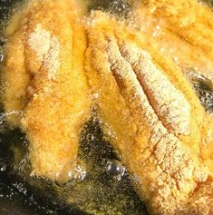 fried food cooking in a frying pan with oil on the bottom and steam coming out