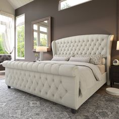 a large white bed sitting inside of a bedroom next to a lamp and window sill