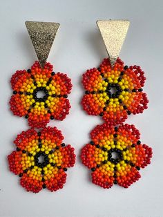 "We absolutely love these easy-to-wear charming Flower Bead earrings that are the perfect piece of summer jewelry. These vibrant earrings are a perfect eye-catching piece needed to complete your look.  The earrings were handmade using ancestral beading techniques. Color: Red, Yellow, Orange, & Red  Metal: Bronze  Metal Color: Gold Size: 3.4\" L x 1.4\" W Check out other similar products in our store and visit us at: https://www.etsy.com/shop/Eklectyc" Orange Beaded Flower Earrings, Beaded Teardrop Flower Earrings As Gift, Beaded Teardrop Flower Earrings For Gift, Flower Shaped Dangling Beads Earrings For Festivals, Flower Shaped Festival Earrings With Dangling Beads, Flower-shaped Festival Earrings With Dangling Beads, Adjustable Flower-shaped Earrings With Colorful Beads, Adjustable Flower Shaped Earrings With Colorful Beads, Colorful Beads Flower Shape Earrings