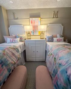 two beds in a small room with colorful comforters and pillows on the bedding