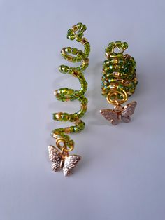 Beaded loc coil made with 4mm green and gold glass seed beads, and gold butterfly charm on brass coil. Fits small to medium locs or braids, hole size 7 to 9mm. Sold individually. Loc Charms Dreadlock Accessories, Loc Decoration, Loc Jewelry On Short Locs, Locs With Shells, Locs With Accessories, Short Locs With Beads, Hair Charms For Braids, Raindrop Braids, Medium Length Loc Styles