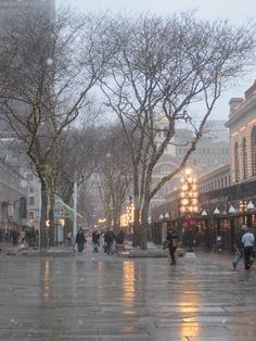 people are walking down the street in the rain