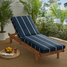 a blue chaise lounger sitting on top of a rug next to a potted plant