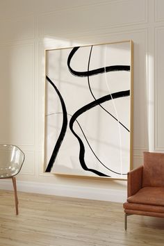 an abstract painting hangs in the corner of a room next to a chair and table