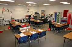 an empty classroom with desks, chairs and bulletin boards on the wall in front of them