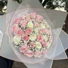 a bouquet of pink and white flowers is held by someone