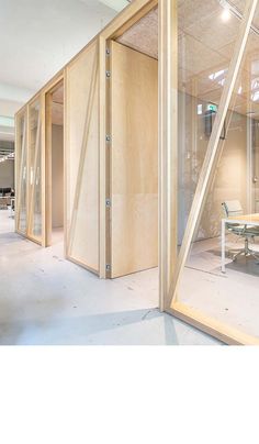 an office with glass walls and wooden partitions