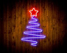 a neon christmas tree on a wooden wall