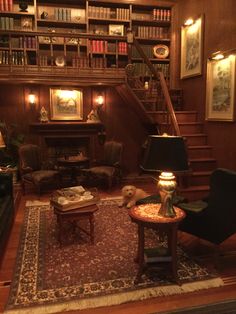 a living room filled with furniture and bookshelves next to a stair case full of books