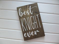 a wooden sign that says best knight ever on the side of a building with white paint