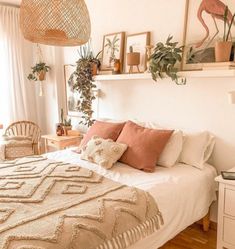 a bedroom with a bed, chair and plants on the wall above it is decorated in neutral colors