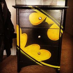 a black and yellow painted dresser next to a coat rack