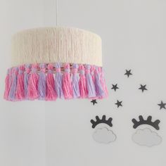 a pink and purple chandelier hanging from the ceiling next to other wall decorations