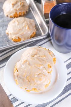 glazed donuts sitting on a plate next to a cup of coffee and baking pan