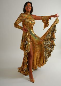 Tango Dress-Spanish Princess will fit size 3/4-9/10...5'6″ or taller, stretchy Be the envy of the dance floor with this stunning Gold Hologram Tango-Paso Doble Dress! Crafted of golden iridescent hologram tiger print lycra, this elegant ensemble boasts lots of flounces, a long sleeve with a peak at the wrist, and shimmering accents courtesy of volcano colored Swarovski rhinestones, which shine several different shades including purple & yellow. Make a statement with two thigh-high slits in the front, and show off your amazing tango leg lines! Sparkle in class and be ready to take on the dance floor in this gorgeous golden dress! You'll feel like a Spanish princess dancing tango or paso doble' in this dress!! This Tango dress design can be custom created in other fabrics & colors, more or l Glamorous Fitted Dress For Ballroom, Fitted Full Length Gold Dress, Gold Fitted Dress For Dance, Gold Fitted Dance Dress, Gold Full-length Fitted Dress, Fitted Full-length Gold Dress, Gold Fitted Full-length Dress, Tiger Party Dress, Gold Latin Dress