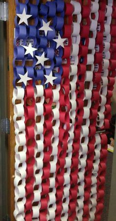 an american flag made out of red, white and blue ribbon hanging on a door