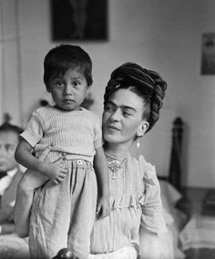 an old black and white photo of a woman holding a child