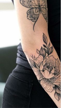 a woman's arm with flowers and butterflies on it