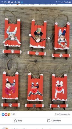 four red sleds with pictures of children in them hanging from strings on a wooden table