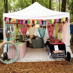 a tent set up in the woods for an outdoor party with flags and streamers