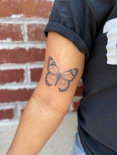 a woman's arm with a butterfly tattoo on the left side of her arm