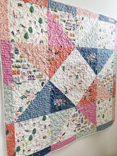 a colorful quilt hanging on the wall